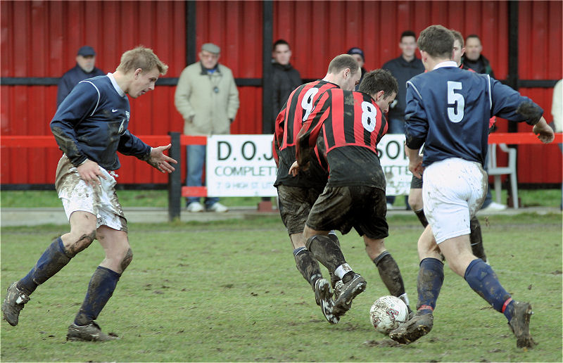 Darren Annis (9) and Marc Cooper (8) try and control the ball in the mud with Duncan Barnes and Stuart Hack (5) looking to get on to it
